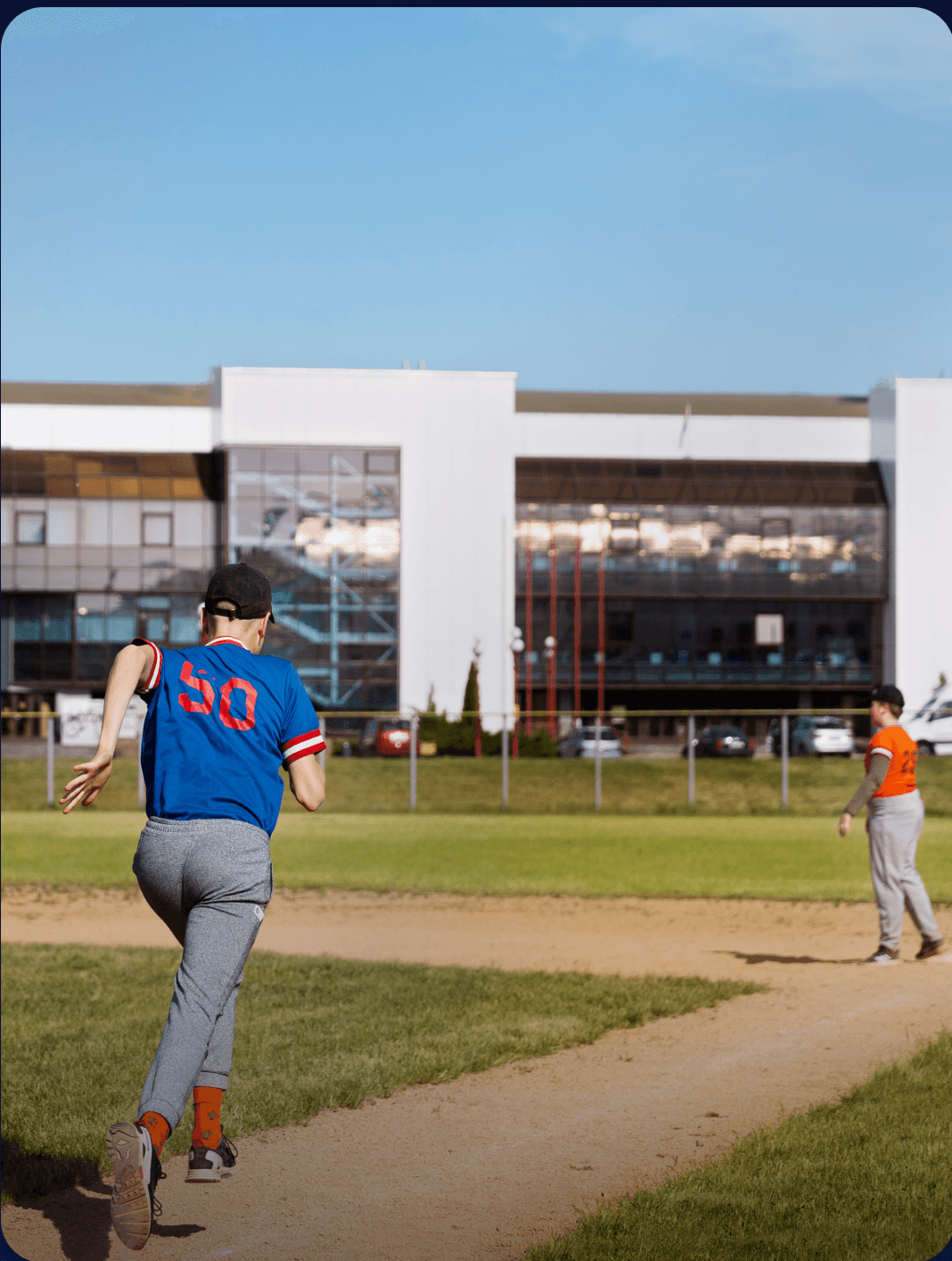 Baseball player running the base path beside the athletics facility